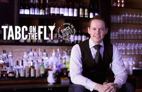 Man sitting in front of a bar with TABC On The Fly logo.