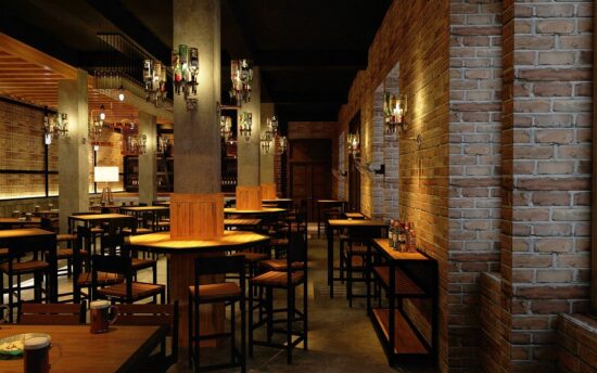 Empty bar interior with tables and brick walls.
