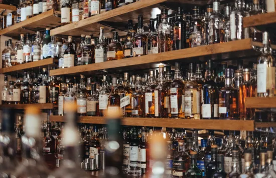 Shelves filled with liquor bottles behind a bar.