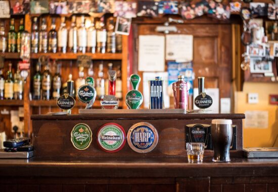 Bar counter with beer taps and bottles behind it.