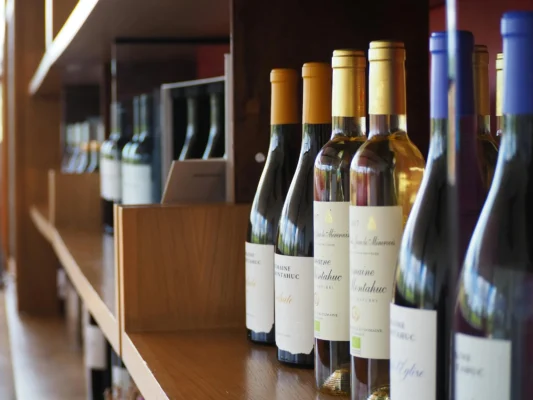 Wine bottles displayed on a wooden shelf.