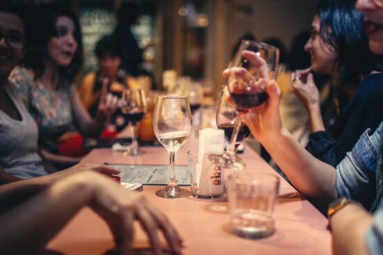 Group of people drinking wine at a restaurant table.
