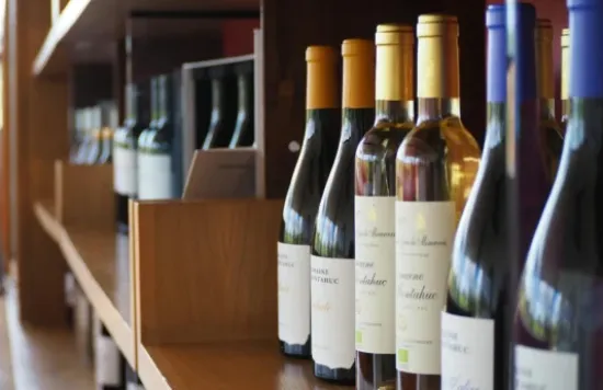 Wine bottles displayed on a wooden shelf.