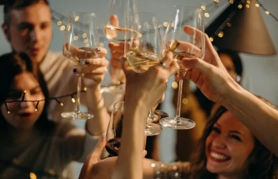 Group of friends toasting wine glasses at a celebration.