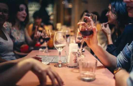 Group of people drinking wine at a restaurant table.