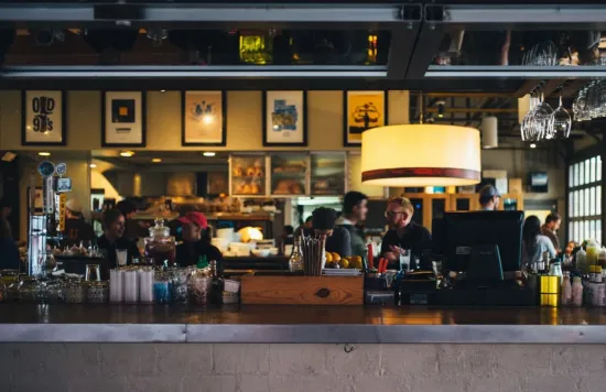 Busy restaurant bar with staff and customers inside.