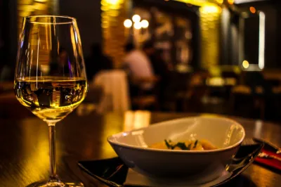 Glass of white wine and a dish on a restaurant table