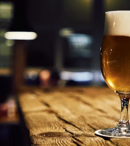 Glass of beer on a wooden bar table