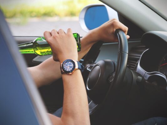 Drinking behind steering wheel of car