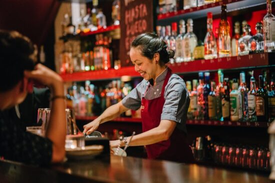 Female Bartender rings up customer