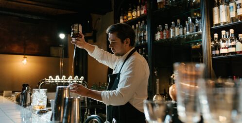 bartender pouring drink behind bar
